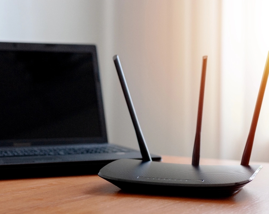 An internet router and a laptop on a desk